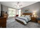 Spacious main bedroom featuring neutral walls, carpet floors, a ceiling fan, and a large window with natural light at 3545 Inverness Blvd, Carmel, IN 46032
