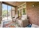 Inviting screened porch with ceiling fan, brick wall, colorful rug and comfortable seating at 3545 Inverness Blvd, Carmel, IN 46032