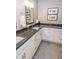 Bathroom featuring double sinks with granite countertops and white cabinets at 355 E Ohio St # 211, Indianapolis, IN 46204