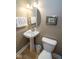 Charming powder room with pedestal sink, decorative mirror, and modern toilet at 355 E Ohio St # 211, Indianapolis, IN 46204
