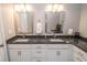 Dual sink bathroom vanity with granite countertops, modern fixtures, and bright lighting at 355 E Ohio St # 211, Indianapolis, IN 46204