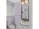 The bathroom includes a mosaic tile accent wall, a white vanity, and a window bringing in natural light at 4010 S Bazil Ave, Indianapolis, IN 46239
