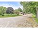 Attractive ranch home with a long gravel driveway and a lush front lawn under a bright sky at 4010 S Bazil Ave, Indianapolis, IN 46239
