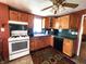Functional kitchen with gas range, dishwasher, wooden cabinetry, and dark green backsplash at 408 W 4Th St, Anderson, IN 46016