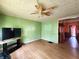 Inviting living room featuring green walls, wood-like flooring, and a ceiling fan at 408 W 4Th St, Anderson, IN 46016