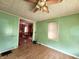 Inviting living room featuring green walls, wood-like flooring, and a ceiling fan at 408 W 4Th St, Anderson, IN 46016