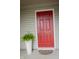 Stylish red front door complemented by a potted fern, enhancing curb appeal at 4114 Dunedin Ct, Noblesville, IN 46062
