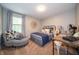 Bedroom featuring neutral walls, a comfortable bed, chair and industrial style desk with vintage fan at 4238 Victory Ct, Indianapolis, IN 46203
