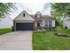 Charming home featuring an attached garage, lush lawn and manicured landscaping at 4238 Victory Ct, Indianapolis, IN 46203