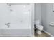Bright bathroom showcases a white shower-tub combination and toilet against gray walls at 5205 Staughton Dr, Indianapolis, IN 46226