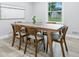Dining area with a modern table and chairs adjacent to a window looking onto the backyard at 5205 Staughton Dr, Indianapolis, IN 46226