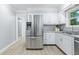 Spacious kitchen with stainless steel refrigerator, white cabinetry, and sleek countertops at 5205 Staughton Dr, Indianapolis, IN 46226