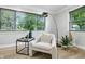 Cozy sitting area with comfortable chair, modern lamp, and serene view through the window at 5205 Staughton Dr, Indianapolis, IN 46226