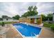 Backyard pool features two shed-style pool houses, privacy, and a well-kept lawn at 524 W Campbell St, Edinburgh, IN 46124