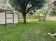 Well-maintained backyard featuring a storage shed, mature trees, and a partial fence at 5331 Yucatan Dr, Indianapolis, IN 46237
