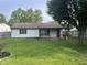 The house's back shows a wooden deck and green lawn, surrounded by trees and a fence at 5331 Yucatan Dr, Indianapolis, IN 46237