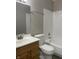 Bathroom featuring single sink vanity, white toilet, tub with white tiles, and light grey walls at 5331 Yucatan Dr, Indianapolis, IN 46237
