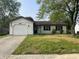 Charming one-story home with a well-kept lawn, attached garage, and an American flag waving at 5331 Yucatan Dr, Indianapolis, IN 46237