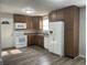 Well-lit kitchen with wooden cabinets, white appliances, laminate countertop, and a white door leading outside at 5331 Yucatan Dr, Indianapolis, IN 46237