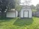 View of sheds in the backyard with lush green grass and mature trees around at 5331 Yucatan Dr, Indianapolis, IN 46237