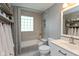 Neutral-toned bathroom with a shower-tub combination, glass block window, and open shelving at 544 Everling Dr, Morgantown, IN 46160