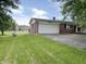 View of home's front, showcasing a lush lawn and a paved driveway leading to the garage at 5667 Broyles Rd, Avon, IN 46123