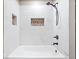 White-tiled tub with a shower and decorative mosaic tile details at 57 E South St, Mooresville, IN 46158