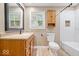 Bathroom showcasing a wood vanity, toilet, and tiled tub with shower at 57 E South St, Mooresville, IN 46158