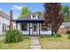 Charming home featuring a front porch with blue trim and manicured landscaping at 57 E South St, Mooresville, IN 46158