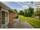 View of the home's brick exterior, patio, and expansive backyard with mature trees at 5749 Teresa Dr, Alexandria, IN 46001
