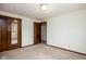 A simple bedroom with neutral walls and carpet, featuring a mirrored closet and a wooden door at 5749 Teresa Dr, Alexandria, IN 46001