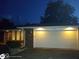 Well-lit two car garage on a single Gathering home's brick facade with updated vinyl windows at 5749 Teresa Dr, Alexandria, IN 46001