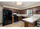 Kitchen with oak cabinets, black appliances, peninsula countertop, and durable floors at 5749 Teresa Dr, Alexandria, IN 46001