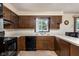 Kitchen with oak cabinetry, white countertop, black appliances, and a window view at 5749 Teresa Dr, Alexandria, IN 46001