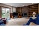 Bright living room with a fireplace, built-in shelves, and access to the outside with a sliding glass door at 5749 Teresa Dr, Alexandria, IN 46001