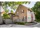 View of the home's backyard with deck, stone retaining wall and lush green foliage at 5760 Central N Ave, Indianapolis, IN 46220
