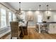 Bright dining room with a chandelier, wooden table with wicker chairs, and a bar with stools at 5760 Central N Ave, Indianapolis, IN 46220