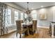 Bright dining room with a chandelier, wooden table with wicker chairs, and lots of natural light at 5760 Central N Ave, Indianapolis, IN 46220
