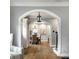 View of dining room with wood table, wicker chairs and overhead chandelier seen through arched doorway at 5760 Central N Ave, Indianapolis, IN 46220