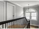 Upstairs hallway with hardwood floors, white trim, and a decorative chandelier at 5760 Central N Ave, Indianapolis, IN 46220