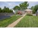 Spacious backyard with brick patio, fire pit, manicured lawn, and garden at 5829 Indianola Ave, Indianapolis, IN 46220