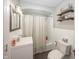 Bright bathroom with white tile, a square mirror, stylish lights, and modern storage shelves at 5829 Indianola Ave, Indianapolis, IN 46220
