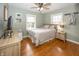 This bedroom features a ceiling fan, hardwood floors, and natural light from two windows at 5829 Indianola Ave, Indianapolis, IN 46220