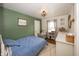 Cozy bedroom with a blue and white plaid bedspread, green accent wall, and stylish light fixture at 5829 Indianola Ave, Indianapolis, IN 46220