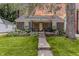 Charming brick home featuring a front porch, well-manicured lawn, and beautiful landscaping at 5829 Indianola Ave, Indianapolis, IN 46220
