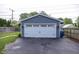 Detached garage with a white garage door and blue siding, and a paved driveway at 5829 Indianola Ave, Indianapolis, IN 46220