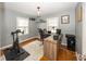 Home office with a large wooden desk, exercise bike, natural light, and neutral color palette at 5829 Indianola Ave, Indianapolis, IN 46220
