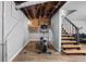 Basement workout area with an elliptical machine, stairs leading up, and visible ceiling pipes at 5946 Guilford Ave, Indianapolis, IN 46220