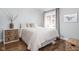 Tranquil bedroom features hardwood floors, decorative nightstand and a bright window at 5946 Guilford Ave, Indianapolis, IN 46220