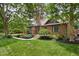 Charming brick home featuring a lush green lawn and mature trees, creating a serene setting at 5946 Guilford Ave, Indianapolis, IN 46220